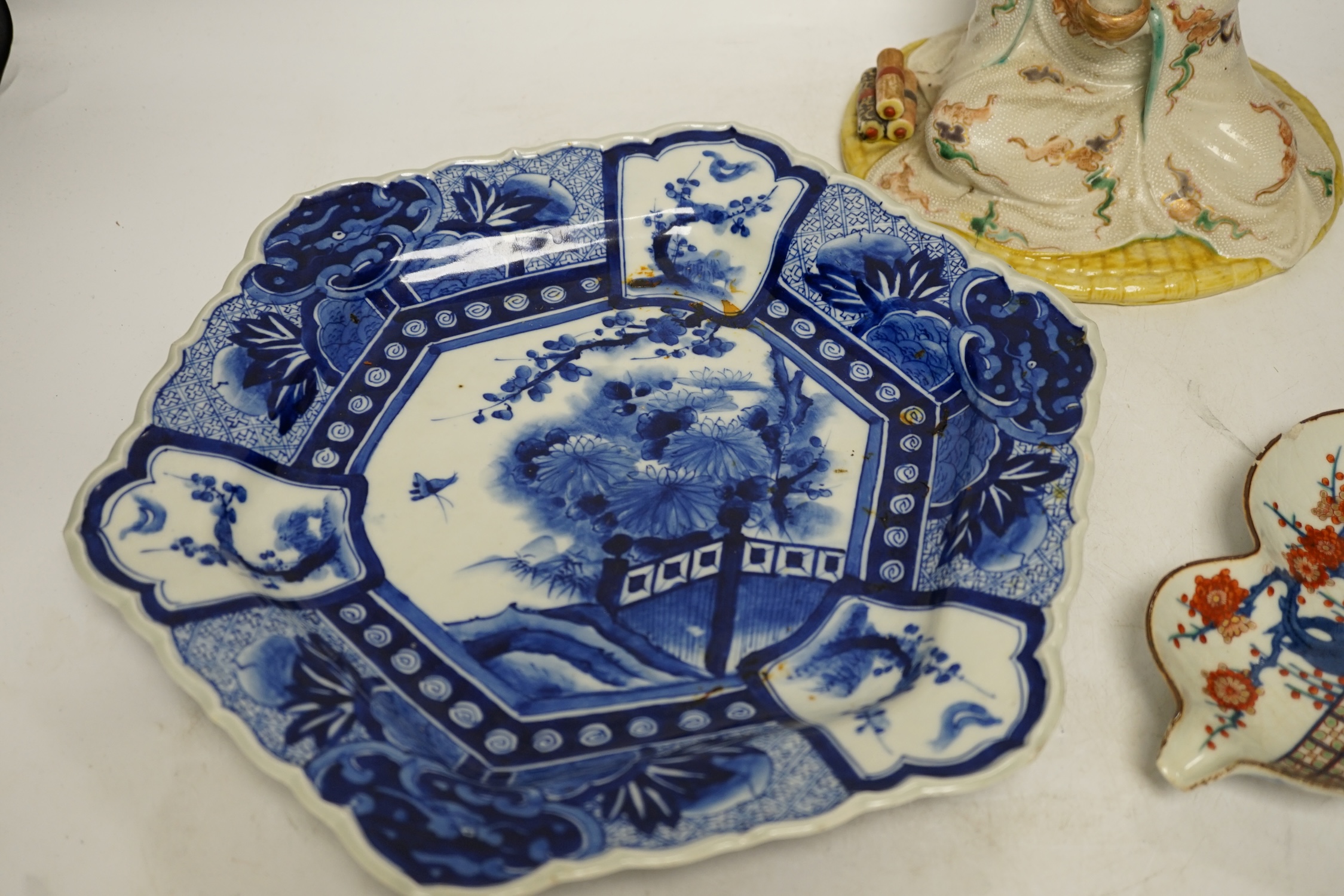 A Japanese seated porcelain figure of Kwannon, an Imari dish and a kakiemon style dish, largest 35cm diameter (3). Condition - blue dish good, others poor to fair